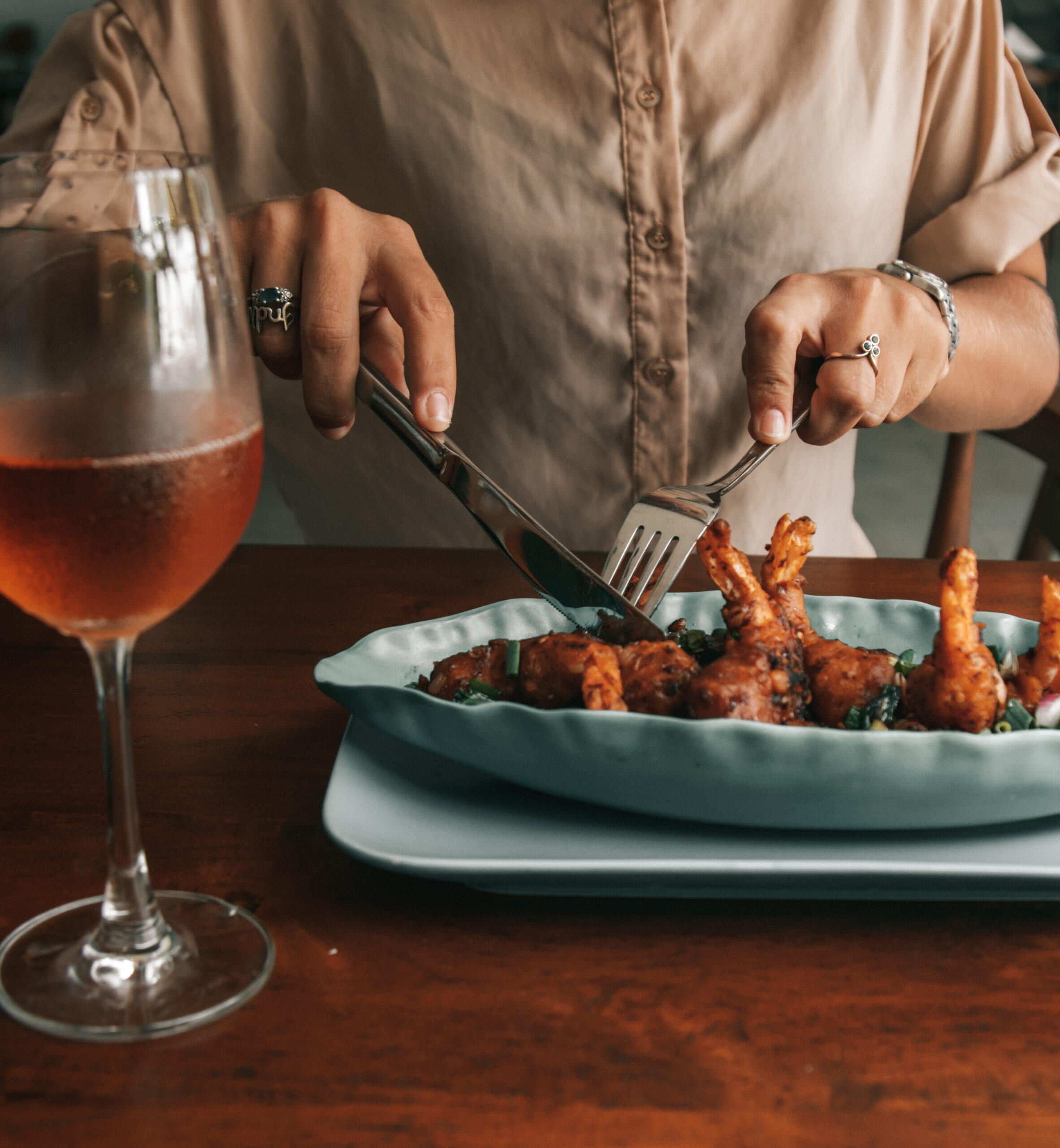 A person enjoying a gourmet meal with cutlery and wine, showcasing refined dining.